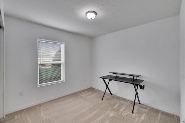 office with a textured ceiling, carpet, and baseboards