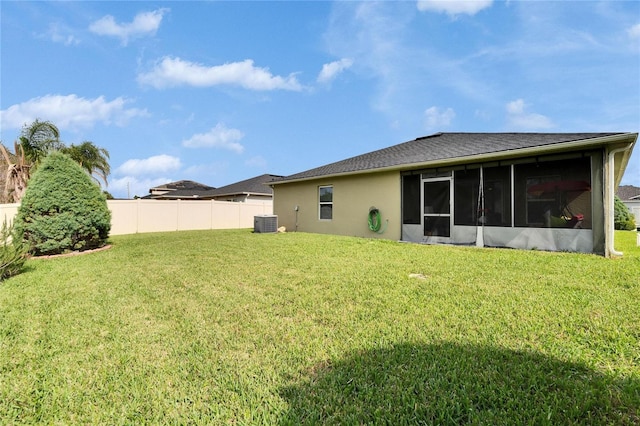 view of yard featuring a sunroom, fence, and central AC unit