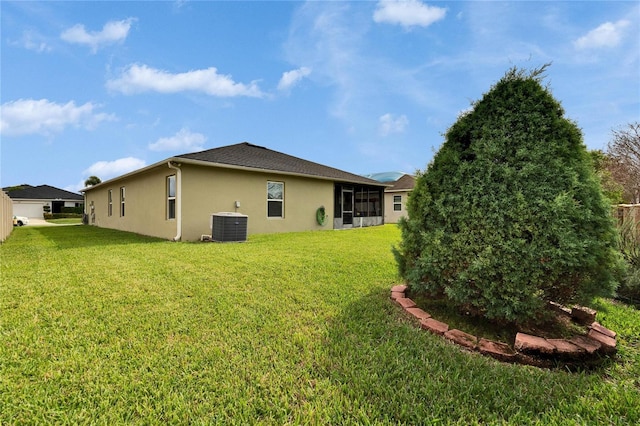 exterior space with central AC unit, a lawn, and stucco siding