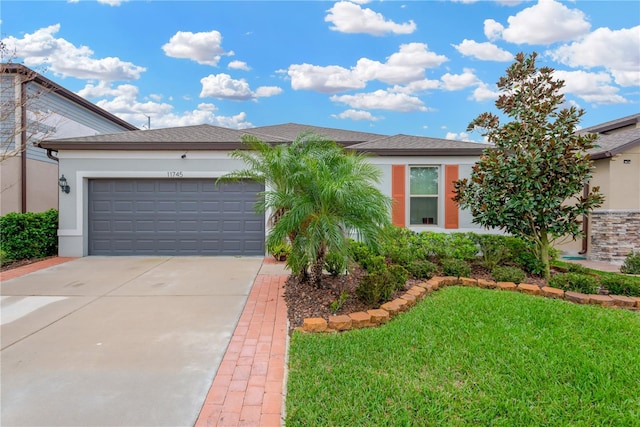 single story home featuring a garage, a front yard, driveway, and stucco siding