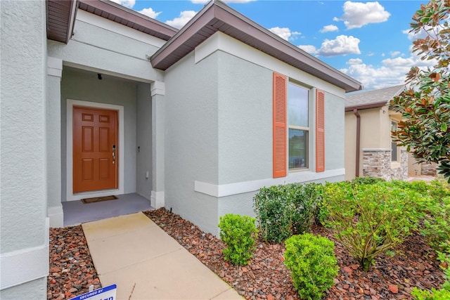 entrance to property featuring stucco siding