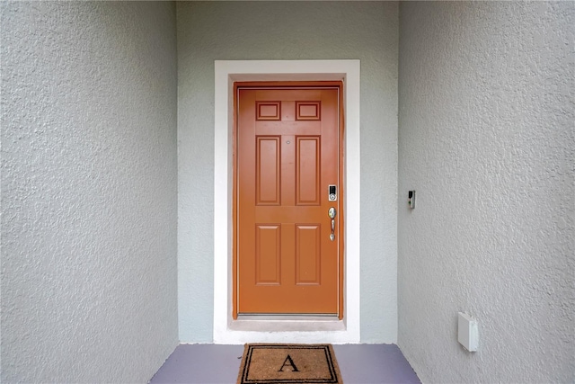 view of exterior entry featuring stucco siding