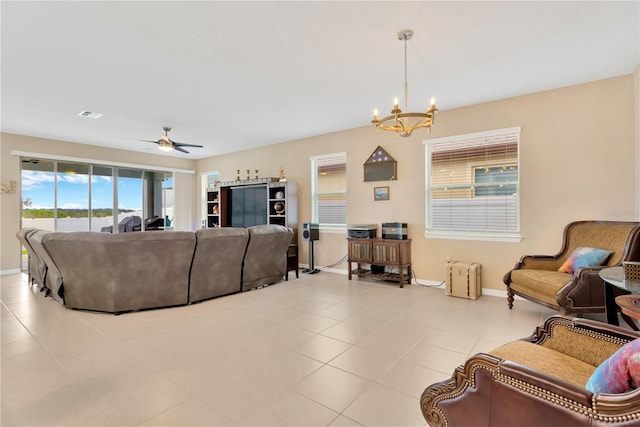 living room with ceiling fan with notable chandelier, light tile patterned floors, visible vents, and baseboards