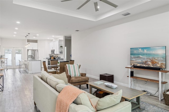 living room featuring baseboards, light wood finished floors, visible vents, and recessed lighting