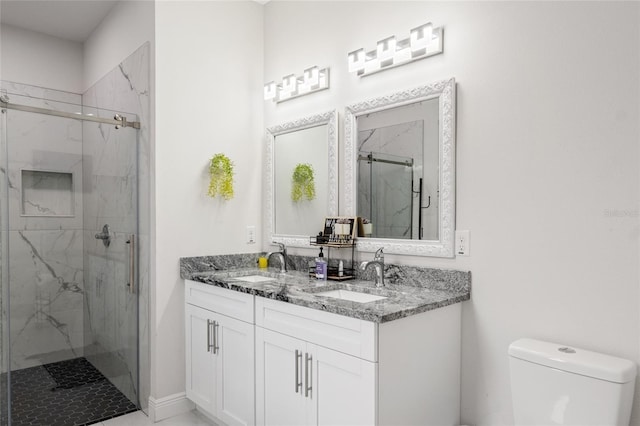 full bathroom featuring a marble finish shower, a sink, toilet, and double vanity