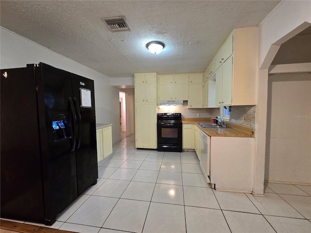 kitchen featuring black appliances, light tile patterned floors, visible vents, and light countertops