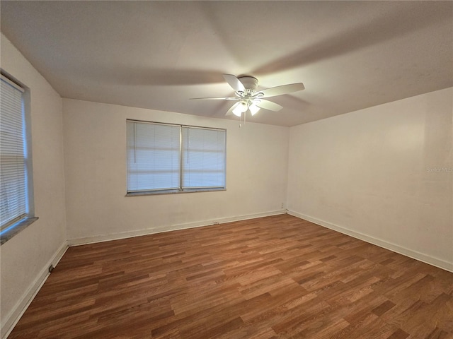 empty room featuring a ceiling fan, baseboards, and wood finished floors