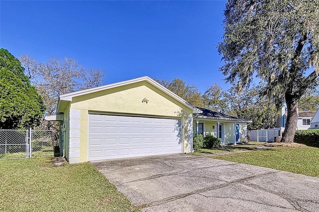 ranch-style house featuring driveway, a front lawn, an attached garage, and stucco siding