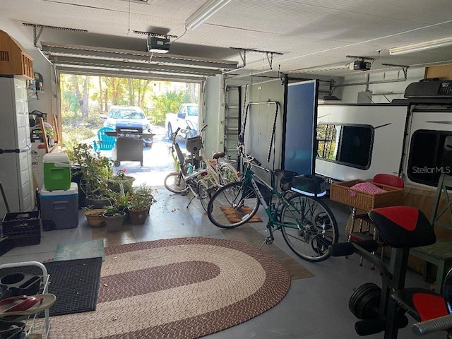 garage with freestanding refrigerator and a garage door opener