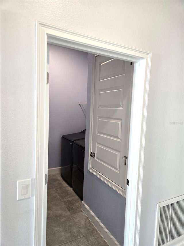 hallway with washing machine and dryer, visible vents, and baseboards