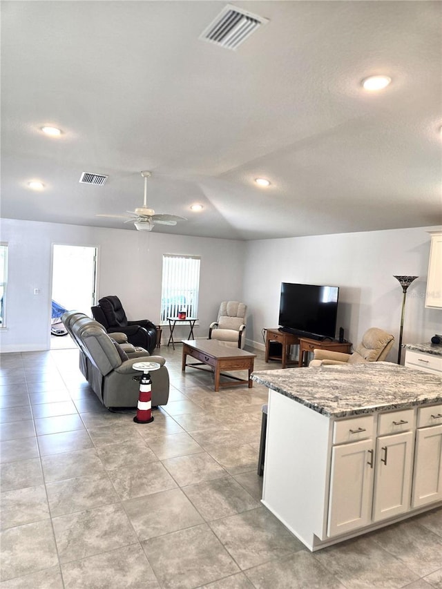 living room featuring visible vents, ceiling fan, and light tile patterned floors