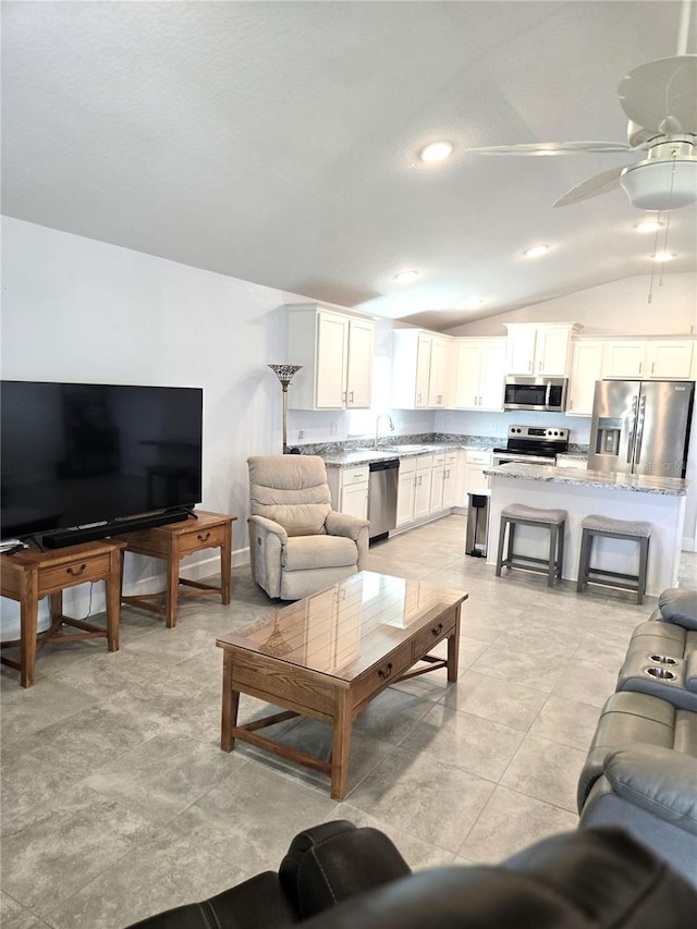 living area with vaulted ceiling and ceiling fan