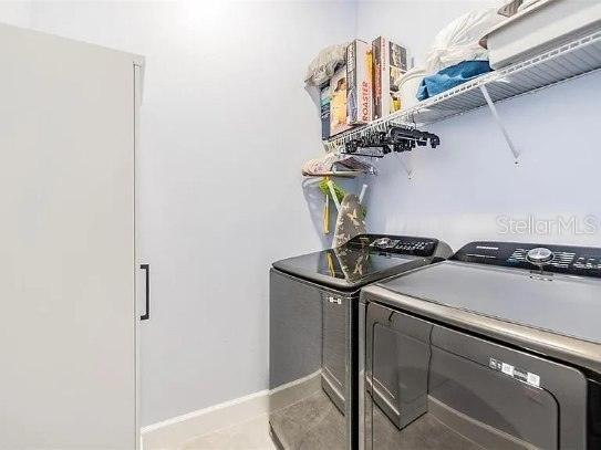 laundry area with laundry area, tile patterned flooring, baseboards, and independent washer and dryer