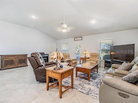 living area featuring lofted ceiling, ceiling fan, and recessed lighting