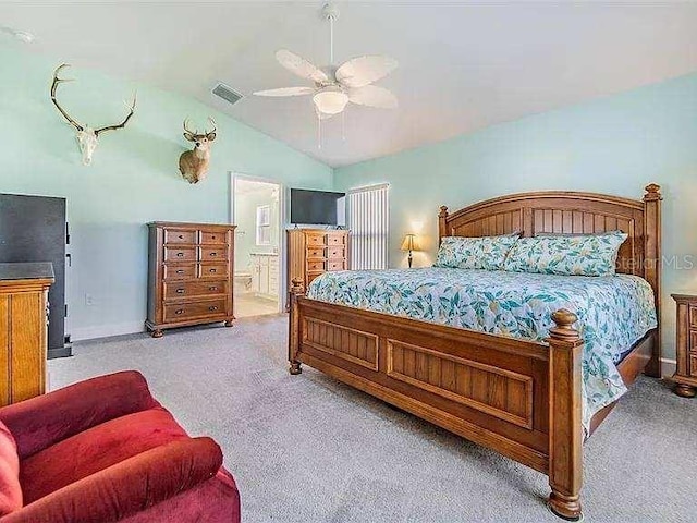 bedroom with vaulted ceiling, carpet, visible vents, and ensuite bathroom