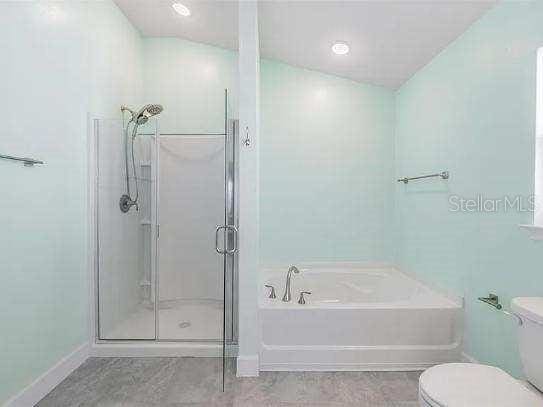 bathroom featuring a garden tub, toilet, and a shower stall