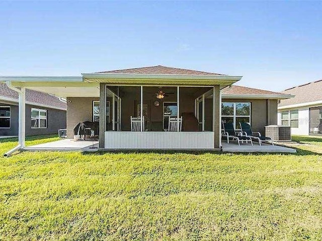 back of house with central AC, a lawn, a patio area, and a sunroom