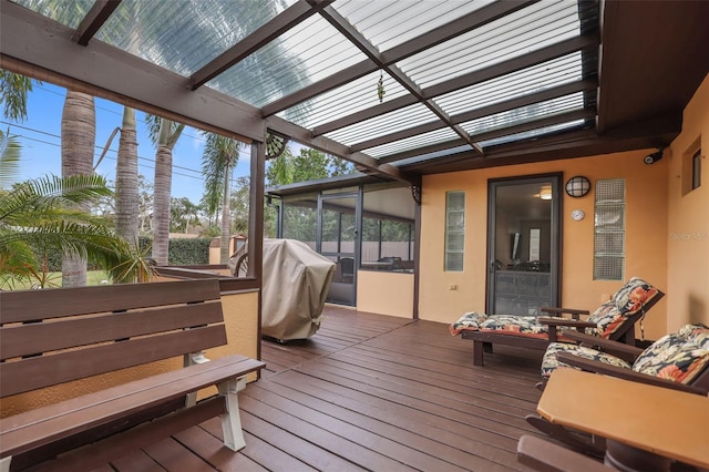 wooden terrace with a sunroom, a pergola, and area for grilling