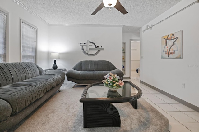 living room featuring light tile patterned floors, a textured ceiling, a ceiling fan, baseboards, and ornamental molding