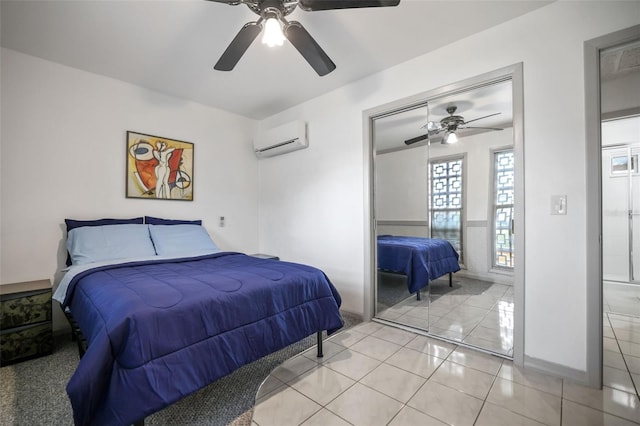 bedroom with a closet, a wall mounted AC, light tile patterned flooring, ceiling fan, and baseboards