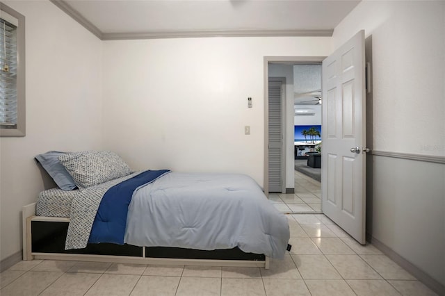 bedroom with light tile patterned floors, baseboards, and ornamental molding