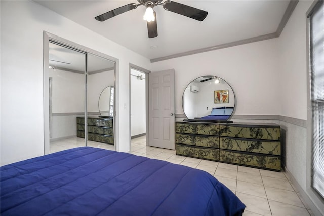 bedroom with light tile patterned floors, ceiling fan, ornamental molding, and a closet