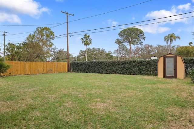 view of yard featuring a fenced backyard, an outbuilding, and a shed