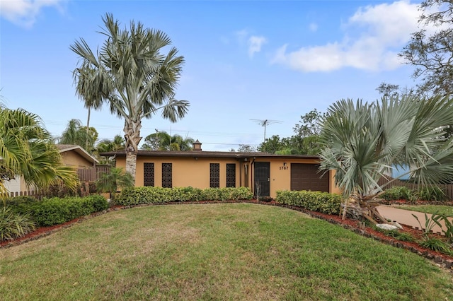 ranch-style home featuring a garage, a front lawn, and stucco siding