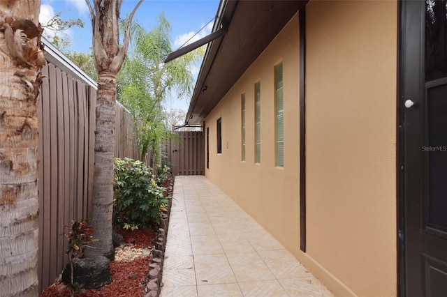 view of side of property with fence and stucco siding