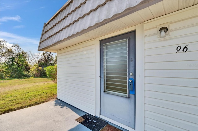 view of exterior entry with a lawn