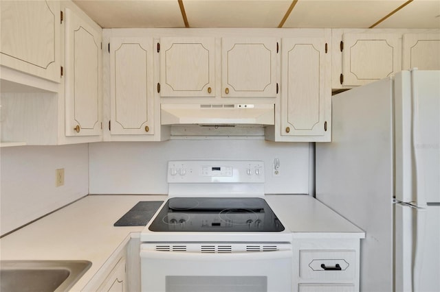 kitchen featuring under cabinet range hood, white appliances, and light countertops