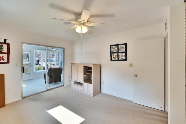 unfurnished living room featuring carpet floors, a ceiling fan, and baseboards