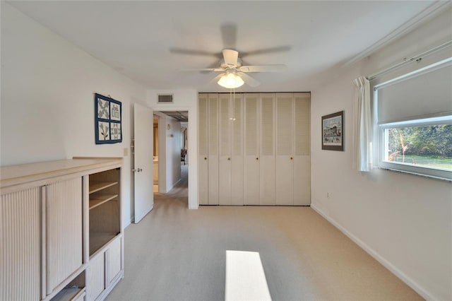 unfurnished bedroom featuring baseboards, visible vents, ceiling fan, and a closet