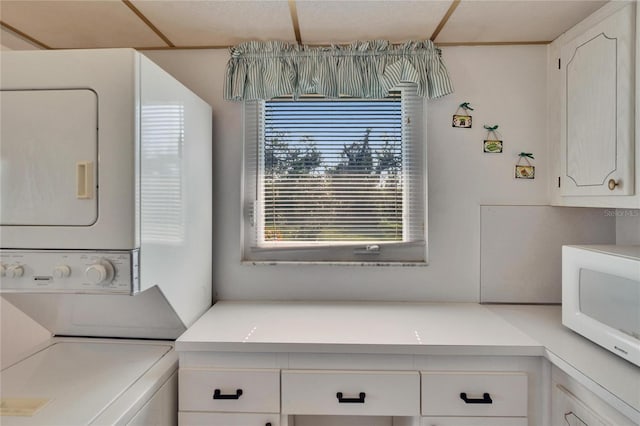 clothes washing area featuring laundry area and stacked washer and clothes dryer
