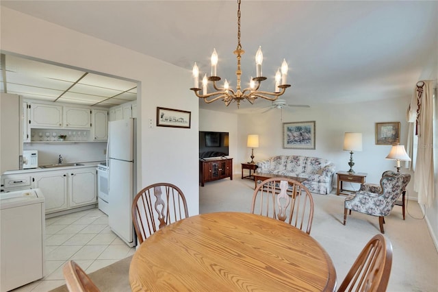 dining area featuring light tile patterned floors, washer / clothes dryer, and a notable chandelier