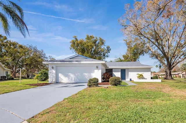 ranch-style home with an attached garage, driveway, a front yard, and stucco siding