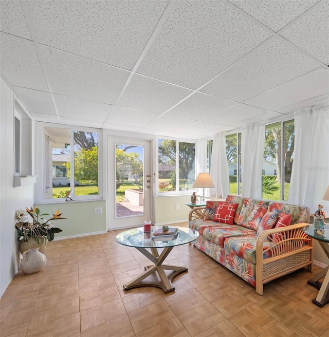 sunroom with a drop ceiling and a wealth of natural light