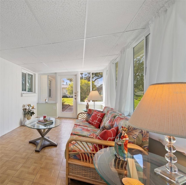 sunroom / solarium featuring a paneled ceiling and plenty of natural light