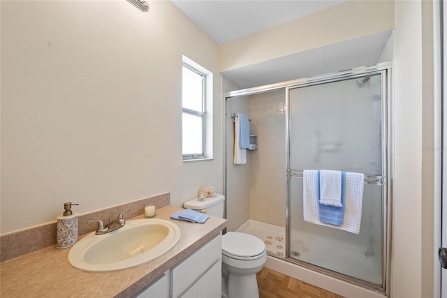 bathroom featuring a stall shower, vanity, and toilet