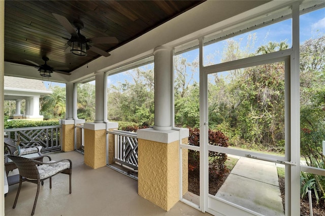 sunroom featuring ornate columns, wood ceiling, and a ceiling fan