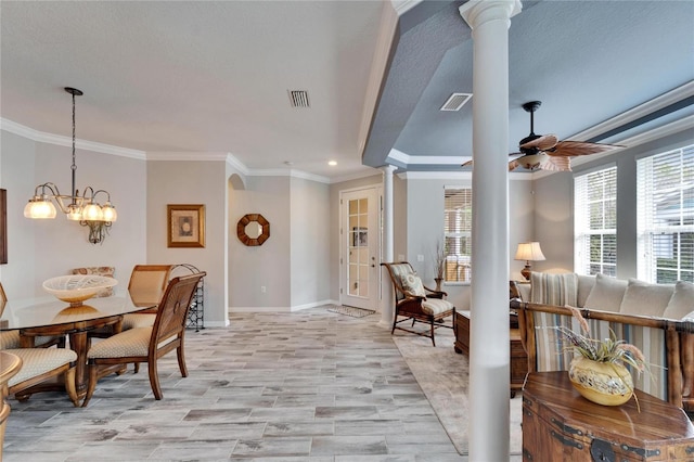 dining area featuring plenty of natural light, decorative columns, ornamental molding, and ceiling fan with notable chandelier