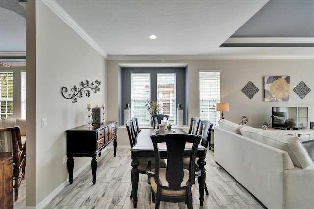 dining area with a textured ceiling, baseboards, crown molding, and wood finish floors