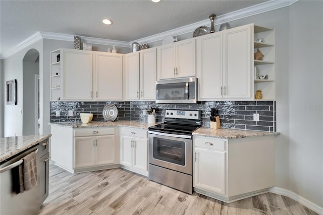 kitchen with stainless steel appliances, light stone counters, open shelves, and white cabinets