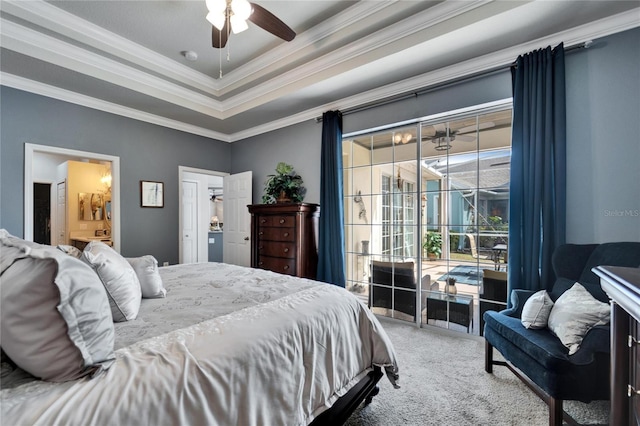 carpeted bedroom featuring access to exterior, a tray ceiling, ornamental molding, a ceiling fan, and connected bathroom