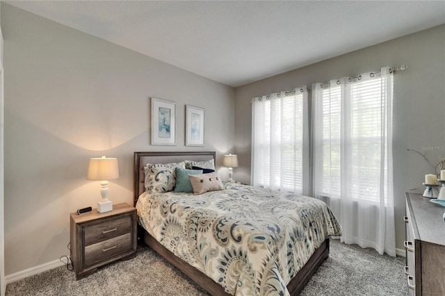 bedroom with light carpet and baseboards