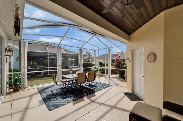 sunroom / solarium with a ceiling fan, wooden ceiling, and vaulted ceiling