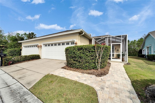 view of front facade with stucco siding, concrete driveway, glass enclosure, a garage, and a front lawn