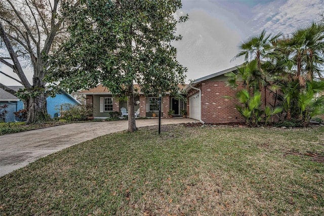 view of front of property with a garage, brick siding, driveway, and a front lawn