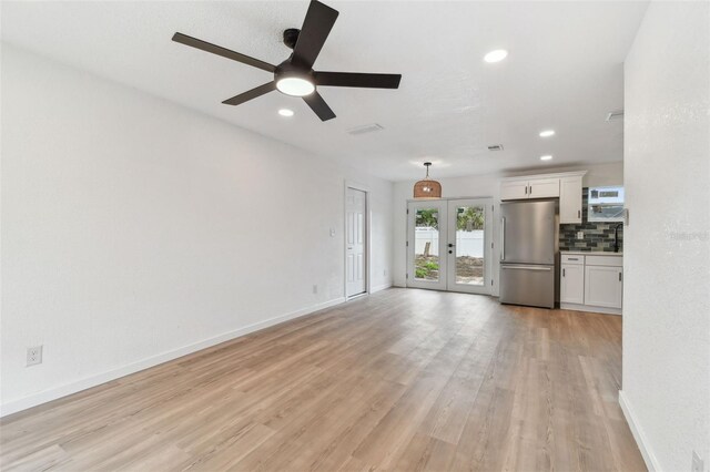 unfurnished living room with recessed lighting, a ceiling fan, baseboards, light wood-style floors, and french doors