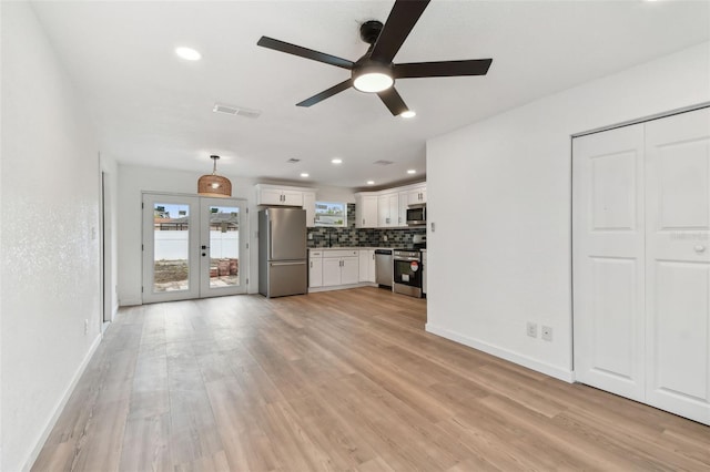 unfurnished living room with a ceiling fan, baseboards, visible vents, light wood-style floors, and french doors